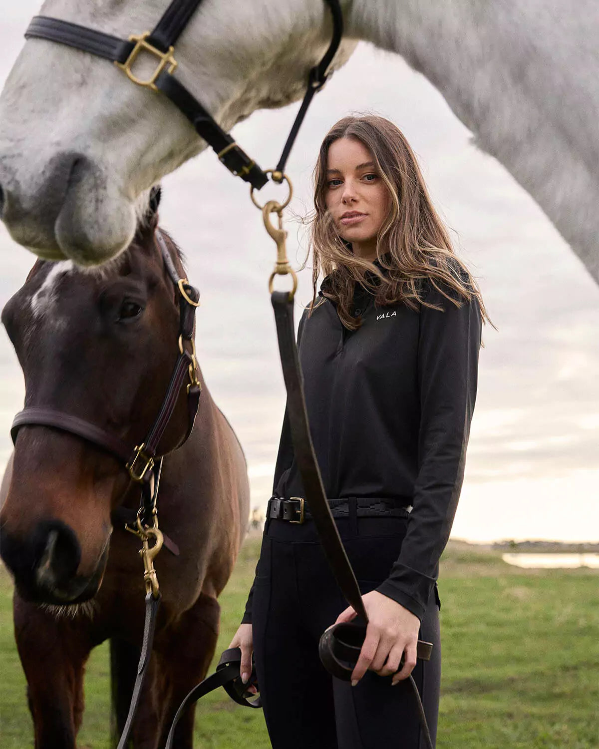 Woman wearing Vala Equestrian long sleeve top with a horse 